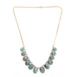 A GOLD AND TURQUOISE NECKLACE having twelve oval-shaped turquoise pendants - 48cm long.
