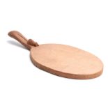 A ROBERT MOUSEMAN THOMPSON OAK CHEESEBOARD of oval form with curved handle and carved mouse