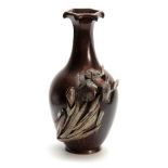 A JAPANESE MEIJI PERIOD PATINATED BRONZE MIXED METAL VASE having a flared faceted neck and applied
