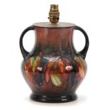 A 20TH CENTURY MOORCROFT LEAVES AND BERRY PATTERN TWIN HANDLED LAMP having flambe glaze with