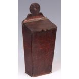 A GEORGE III TAPERING OAK CANDLE BOX with ring-shaped back and hinged cover 42cm high 17.5cm wide