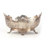 A GEORGE V SILVER CENTER BASKET of pierced scrollwork design supported on four fluted feet 26.5cm