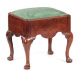 A GEORGE I WALNUT STOOL with shaped side rails, fluted corners and drop-in seat; standing on