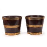 A PAIR OF GEORGE III BRASS BOUND MAHOGANY BUCKETS of coopered tapering form 25cm high 29cm