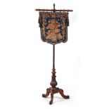AN EARLY VICTORIAN WALNUT POLE SCREEN with blue ground floral needlework panel on a rise and fall