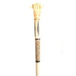 A 19th CENTURY SCRIMSHAW WHALE BONE WALKING CANE having a clenched fist marine ivory handle above