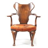AN EARLY 20TH CENTURY WALNUT OPEN ARMCHAIR IN THE MANER OF GILLOWS with figured shaped back splat,
