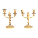 A PAIR OF 19TH CENTURY FRENCH ORMOLU TWO BRANCH CANDELABRA on circular ornate cast bases with flambe