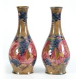 A PAIR OF 20TH CENTURY MOORCROFT VASES decorated with pomegranates and grapes bearing green