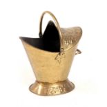 A LATE VICTORIAN OVAL HOODED EMBOSSED BRASS COAL SCUTTLE of oval footed form with folding handle