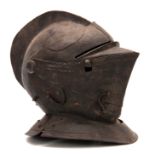 A CLOSE HELMET with a one-piece skull and comb, and hinged visor 31cm high