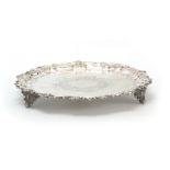 A VICTORIAN SILVER SALVER with scrolled leaf work piecrust border and engraved scrollwork centre; on