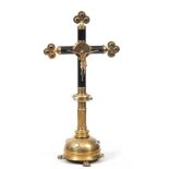 A 19TH CENTURY BRASS AND EBONISED ALTER CRUCIFIX having gilt bronze Christ, red clear glass