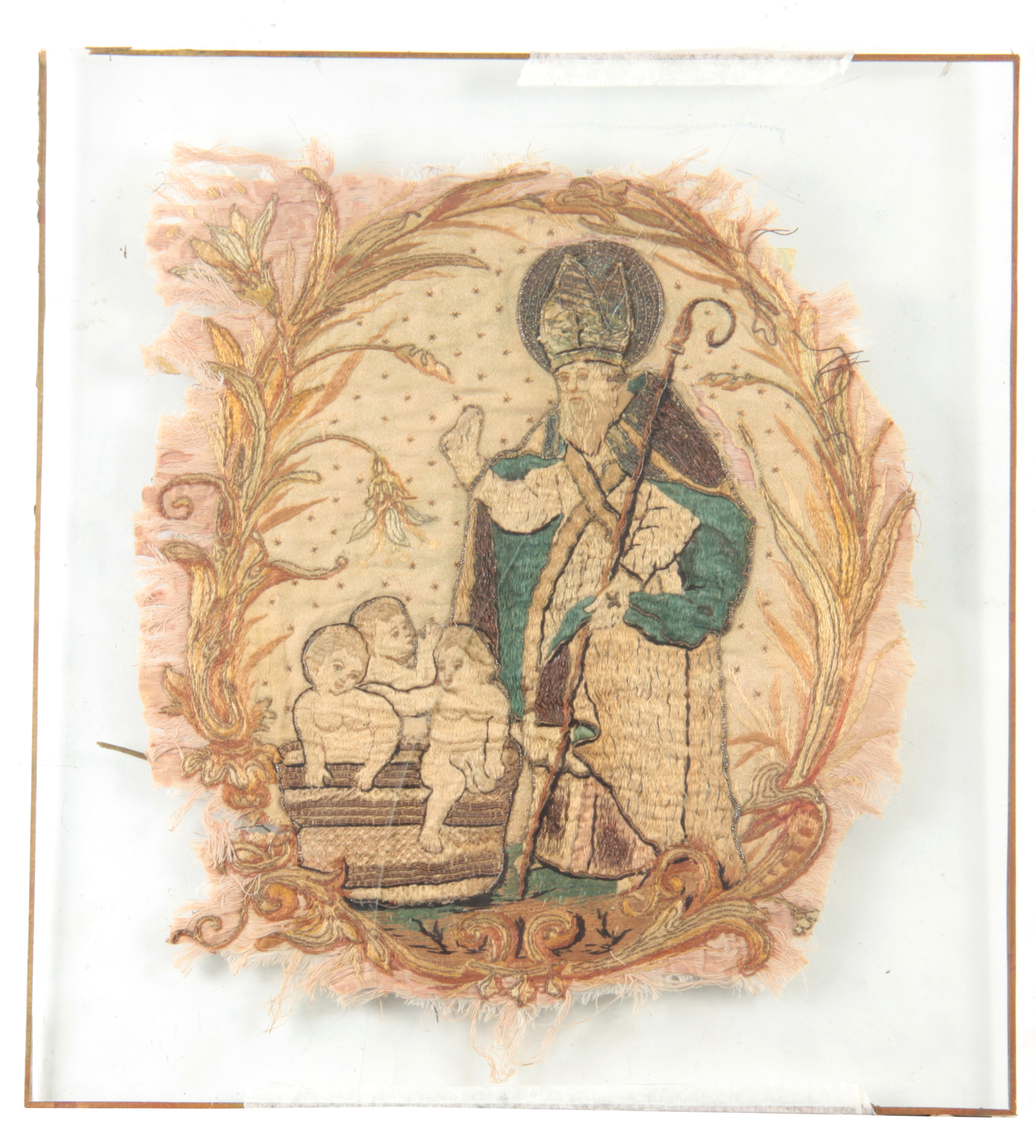 A 17TH CENTURY SILK EMBROIDERED STUMPWORK PANEL depicting a standing Saint with three infants in a