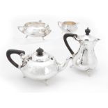 A SILVER ARTS & CRAFTS DESIGN FOUR-PIECE TEA SERVICE having planished bodies and ebony handles,