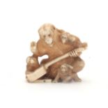 A MEIJI PERIOD JAPANESE IVORY OKIMONO modelled as a group of monkeys holding a Shamisen instrument