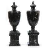 A PAIR OF 20TH CENTURY BLACK VEINED MARBLE URNS with shaped tops and plinth bases 48cm high.