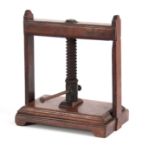 AN 18TH CENTURY MAHOGANY BOOK PRESS of small proportions with central screw mechanism on raised feet