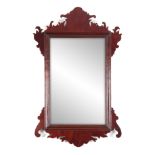 A 20TH CENTURY MAHOGANY FRET-CUT HANGING MIRROR having a rectangular mirror plate surrounded by a