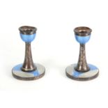 A PAIR OF 1930'S ART DECO SILVER AND ENAMEL CANDLESTICKS having blue and grey engine-turned