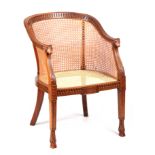 A LATE 19TH CENTURY ADAM STYLE BERGERE CHAIR with arcaded shaped back and rams head arms above