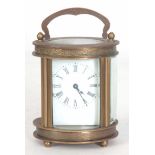 A LATE 20th CENTURY OVAL CASED CARRIAGE CLOCK having chased scrollwork decoration enclosing a 40mm