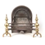 A 19TH CENTURY CAST IRON FIREGRATE with detachable brass dogs and an arched moulded back 72cm high