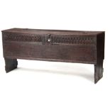 A 17TH CENTURY OAK PLANK COFFER / SWORD BOX OF LARGE SIZE with moulded edge hinged top fitted with