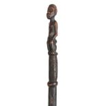 AN AFRICAN CARVED EBONISED WALKING CANE the handle modelled as a seated figure 96cm overall