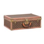 A VINTAGE LOUIS VUITTON BROWN LEATHER SUITCASE with studded brass corner mounts and angle straps
