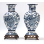 A PAIR OF ORIENTAL BLUE AND WHITE BALUSTER VASES WITH PIERCED METAL BASES AND SCROLL FEET allover