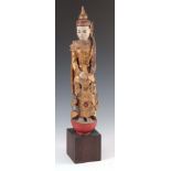 A CARVED STATUE OF A WOODEN BUDDHA mounted on a square wooden base 68cm high.