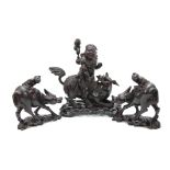 A LATE 19th CENTURY CHINESE HARDWOOD FIGURE RIDING A FOO DOG with glass eyes and bone teeth standing