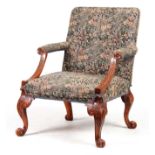 A LATE 19TH CENTURY WALNUT GEORGE I STYLE GAINSBOROUGH CHAIR with upholstered back and sweeping arms