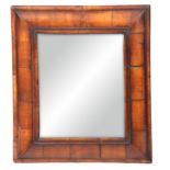 A 19TH CENTURY WILLIAM AND MARY STYLE WALNUT CUSHION FRAMED HANGING MIRROR with cross-grained
