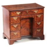 A GEORGE I HERRING-BANDED BURR WALNUT KNEEHOLE DESK with moulded edge top and rounded corners