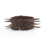 A 19TH CENTURY IRON TURKISH DOG COLLAR having spikes for repelling wolves with a hasp and staple