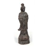 A 19TH CENTURY CHINESE BRONZE FIGURE OF GUANYIN mounted on a naturalistic base 96cm high.