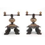 A PAIR OF VICTORIAN BRONZE AND IRON FIRE DOGS having lions paw feet, shell decoration and