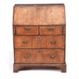 A SMALL EARLY 18TH CENTURY WALNUT BUREAU having an angled hinged fall revealing an interior of small