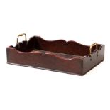 A GEORGE III MAHOGANY LIBRARY TRAY with shaped raised sides and fitted brass carrying handles 51cm