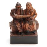 A CONTINENTAL POLYCHROME CARVED FIGURE GROUP depicting a couple seated on a log 15cm wide 19cm high