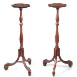 A PAIR OF GEORGE III MAHOGANY HEPPLEWHITE STYLE TORCHERES / CANDLESTANDS of shaped design standing