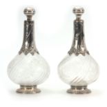 A PAIR OF EARLY 19TH CENTURY CONTINENTAL SILVER MOUNTED BULBOUS DECANTERS the swirl fluted bodies