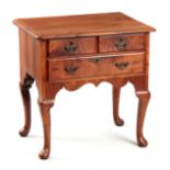 AN 18TH CENTURY FIGURED WALNUT LOWBOY with three drawers fitted with shaped brass handles;