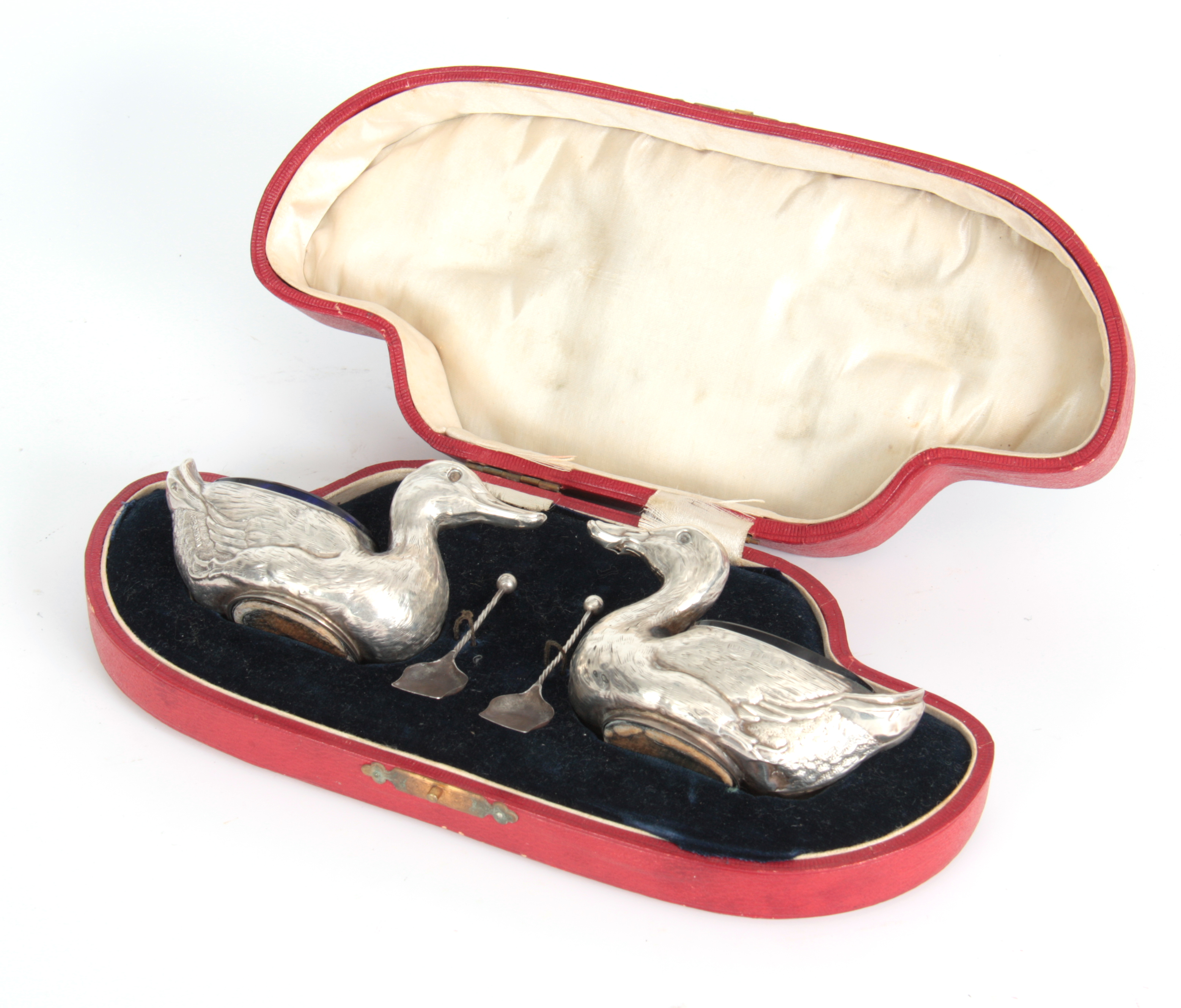 A CASED PAIR OF FIGURAL SILVER SALTS MODELLED AS DUCKS WITH SHOVEL SHAPED SALT SPOONS hallmarked for