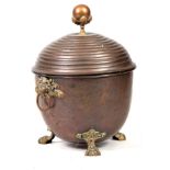 A 19TH CENTURY REGENCY COPPER AND BRASS LIDDED COAL BUCKET having looped lion mask handles, lion paw