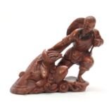 A LATE 19th CENTURY CHINESE HARDWOOD CARVED FIGURE modeled as a fisherman pulling in his catch,