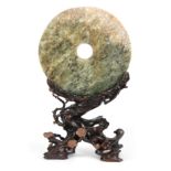 A LARGE 18th/19th CENTURY CHINESE JADE PI ON HARDWOOD STAND the large circular spinach green jade