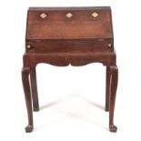 AN 18TH CENTURY OAK BUREAU ON STAND with hinged angled fall fitted with three iron locks having